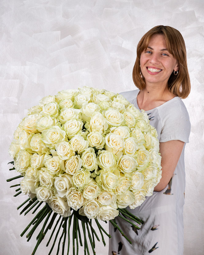 buchet din 101 trandafiri albi tinut de femeie cu zambet