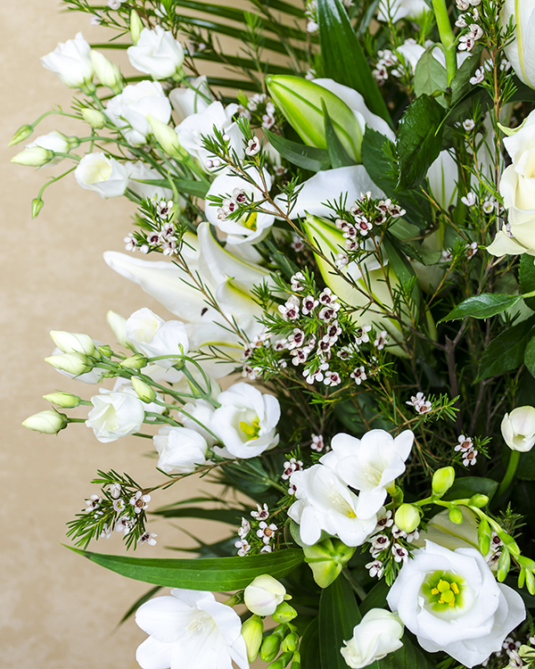 Funeral arrangement with roses, lilies and freesias