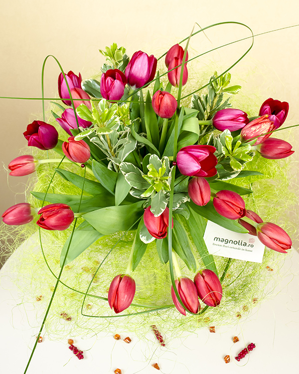 Bouquet with 27 red tulips in a pink sisal holder
