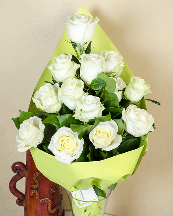 13 white roses with salal leaves