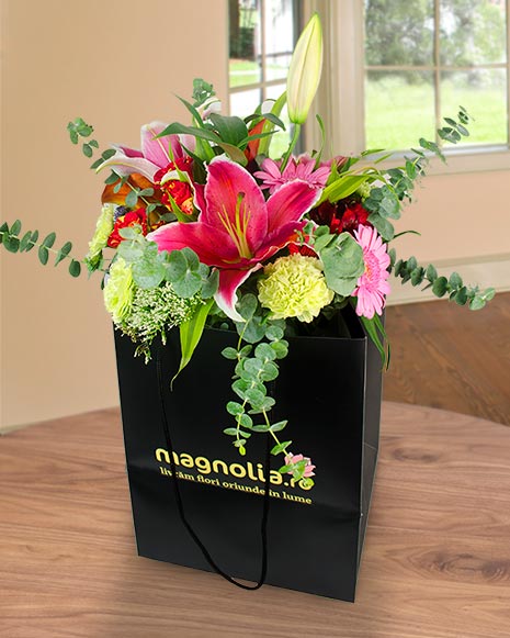 Bouquet of lilies and roses in a gift bag