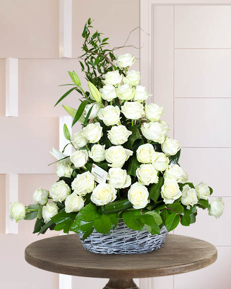 Funeral arrangement with roses and white lilies