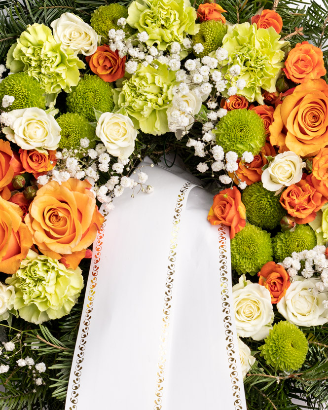 Funeral wreath with orange roses and carnations