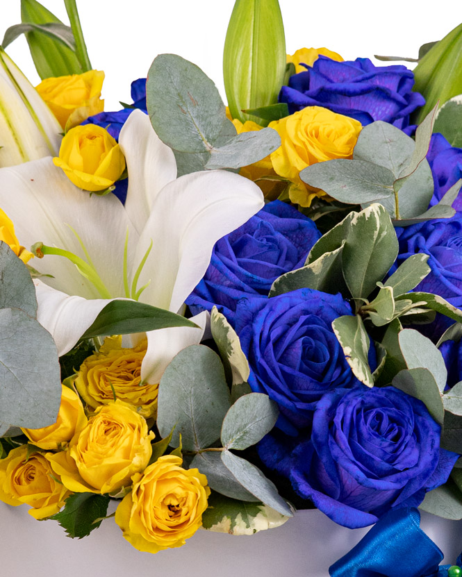 Arrangement in box with blue and yellow roses