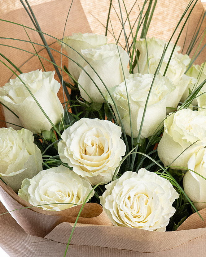 White roses bouquet decorated with greenery