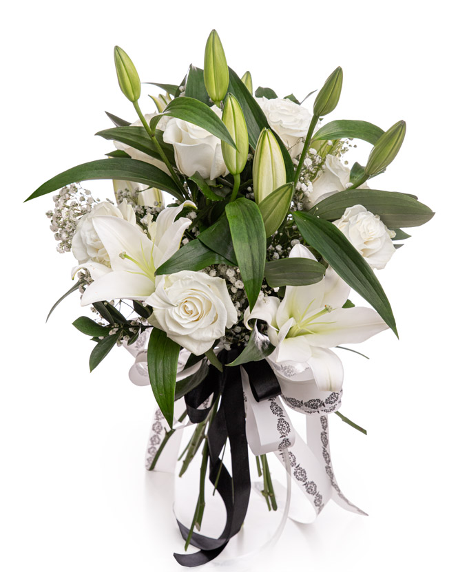 Funeral bouquet with roses, lilies, and gypsophila