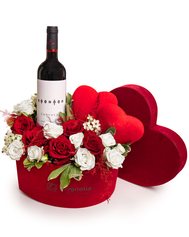 Aranjament romantic cu trandafiri și o sticlă de vin roșu