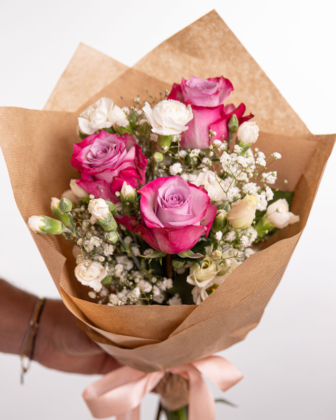 Crown of white natural flowers and bouquet of purple roses