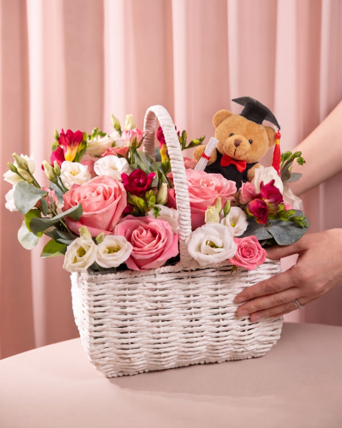 Proportia si dimensiunea pentru Cos cu flori pentru final de an scolar Proud Moment, varianta Premium, compus din, doua eustome albe, patru frezii cyclamen, trei trandafiri ramificati roz, trei trandafiri roz