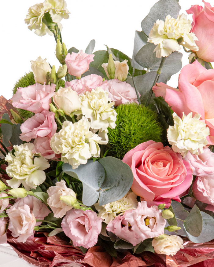 Prim-plan al florilor din buchetul Duetul florilor, varianta Premium, evidentiand combinatia armonioasa de 3 trandafiri roz, 10 garoafe verzi, 3 fire de lisianthus roz si 3 garoafe puf, completate de 2 crengute de eucalipt si 2 crengute de ruscus mic, finisate cu un ambalaj decorativ si 2 panglici elegante.