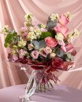 Perspectiva care evidentiaza proportiile si dimensiunea buchetului Duetul florilor, varianta Premium, o compozitie bogata alcatuita din 3 trandafiri roz, 10 garoafe verzi, 3 fire de lisianthus roz si 3 garoafe puf, finisata elegant cu 2 crengute de eucalipt, 2 crengute de ruscus mic, un ambalaj decorativ si 2 panglici.