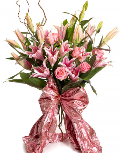 Imagine de ansamblu a buchetului “Buchet trandafiri si crini roz”, varianta Premium, realizat din 7 crini orientali roz, 8 trandafiri roz, 3 ramuri de corylus, 12 frunze de aspidistra, completat cu 2 ambalaje decorative.