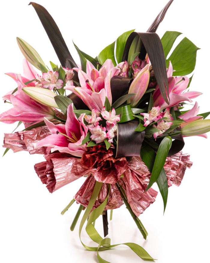 Imagine de ansamblu a buchetului “Buchet crini orientali”, varianta Premium, realizat din 3 Crini orientali roz, 1 frunză de Monstera, 5 frunze de Cordiline, 4 flori de Alstroemeria, completat cu 1 element decorativ și o panglică neînscripționată.