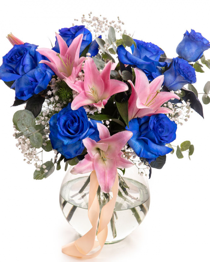 Imagine de ansamblu a buchetului “Buchet cu Trandafiri albaștri și Crini roz „Blue Charm””, varianta Premium, realizat din 2 crini imperiali roz, 7 trandafiri albaștri, 2 fire de Gypsophila, 2 fire de Asparagus umbelatus și 3 crenguțe de Eucalipt, completat cu 2 panglici neînscriptionate.