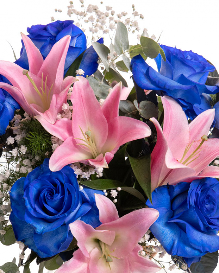 Prim-plan al florilor din buchetul “Buchet cu Trandafiri albaștri și Crini roz „Blue Charm””, varianta Premium, evidentiind combinatia armonioasa de 2 crini imperiali roz, 7 trandafiri albaștri și 2 fire de Gypsophila, completate de 2 fire de Asparagus umbelatus și 3 crenguțe de Eucalipt și finisate cu 2 panglici neînscriptionate elegante.