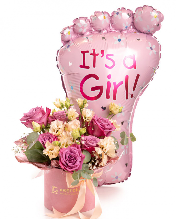 Imagine de ansamblu a aranjamentului “Aranjament floral „It'a a Girl””, varianta Premium, realizat din 7 Trandafiri mov, 1 fir de Gypsophila, 2 flori de Eustoma somon, 2 crenguțe de Cinerea, completat cu 1 panglică neinscripționată, 1 perlă cu ac, ambalaj decorativ și 1 balon roz.