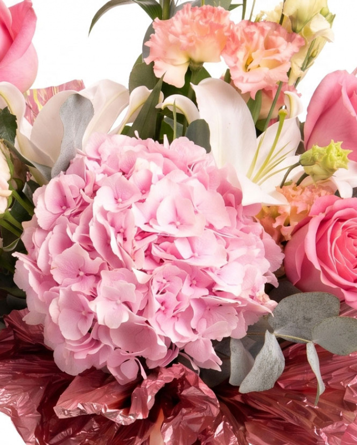 Prim-plan al florilor din buchetul “Buchet de flori „Bucurie de vară"”, varianta Standard, evidențiind combinația armonioasă de 1 Crin imperial alb, 1 fir de Eustoma somon, 1 Hydrangea roz, 1 fir de Trandafir ramificat roz și 3 Trandafiri roz, completate de crenguțe de Eucalipt și finisate cu o panglică elegantă.