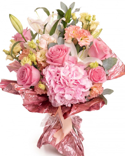 Imagine de ansamblu a buchetului “Buchet de flori „Bucurie de vară"”, varianta Premium, realizat din 2 Crini imperiali albi, 3 crenguțe de Eucalipt, 3 fire de Eustoma somon, 1 Hydrangea roz, 1 fir de Trandafir ramificat roz și 5 Trandafiri roz, completat cu un ambalaj festiv și o panglică.