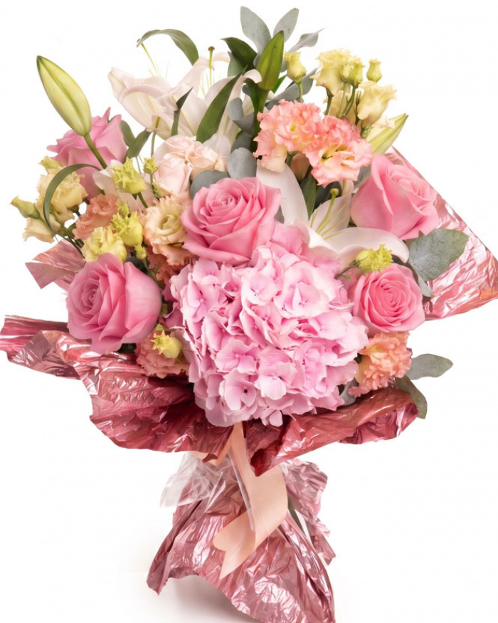Imagine de ansamblu a buchetului “Buchet de flori „Bucurie de vară"”, varianta Premium, realizat din 2 Crini imperiali albi, 3 crenguțe de Eucalipt, 3 fire de Eustoma somon, 1 Hydrangea roz, 1 fir de Trandafir ramificat roz și 5 Trandafiri roz, completat cu un ambalaj festiv și o panglică.