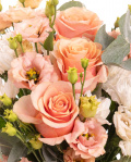 Prim-plan al florilor din buchetul “Buchet cu trandafiri şi crizanteme”, varianta Premium, evidentiind combinatia armonioasa de 3 Crizanteme albe, 5 Trandafiri portocalii, 5 fire de Eustoma somon, completate de 4 crenguţe de Eucalipt si finisate cu 2 panglici inscripţionate Magnolia elegante.