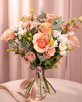 Perspectiva care evidentiaza proportiile si dimensiunea buchetului “Buchet cu trandafiri şi crizanteme”, varianta Premium, o compozitie bogata alcatuita din 3 Crizanteme albe, 5 Trandafiri portocalii, 5 fire de Eustoma somon, 4 crenguţe de Eucalipt, finisata elegant cu 2 panglici inscripţionate Magnolia.