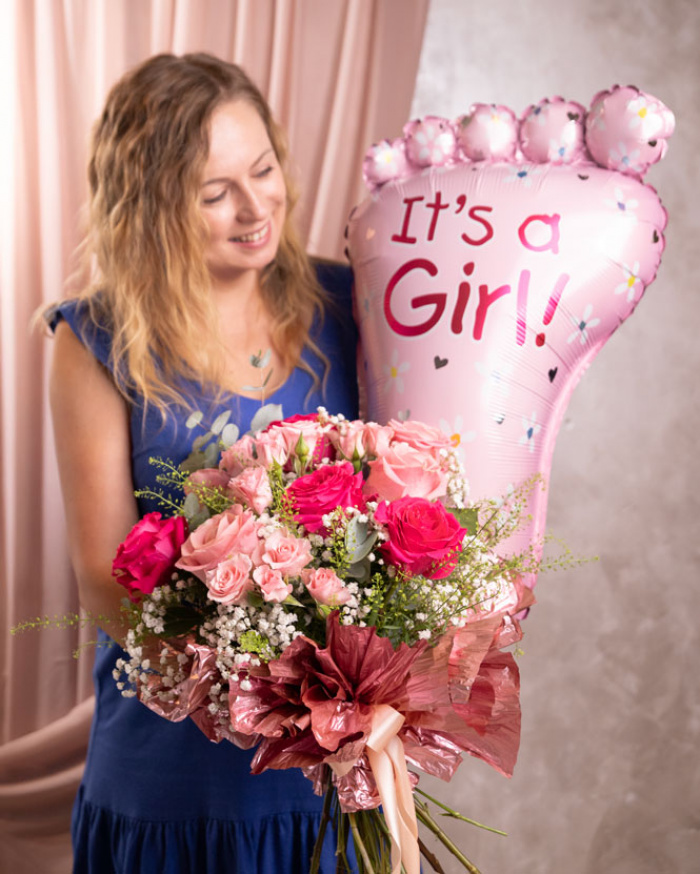 Perspectivă care evidențiază proporțiile și dimensiunea buchetului “Buchet nou-născut „Sweet Baby Girl””, varianta Premium, o compoziție bogată alcătuită din 4 Trandafiri Pink Floyd, 4 Trandafiri roz, 3 Trandafiri ramificați roz, 2 fire de Gypsophila, 2 fire de Lepidium, 3 crenguțe de Eucalipt, finisată elegant cu un balon tematic It's a Girl, ambalaj decorativ și o panglică neinscripționată.