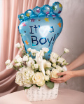 Perspectiva care evidentiaza proportiile si dimensiunea coșului “Coș cu flori nou-născut „Welcome Baby Boy””, varianta Premium, o compozitie bogata alcatuita din 2 Hydrangea albe, 5 Trandafiri albi, 3 fire de Eustoma albă, 3 Trandafiri ramificați albi, 1 Limonium mic, 2 fire de Asparagus umbelatus, finisata elegant cu un coș alb, o panglică și un balon festiv.