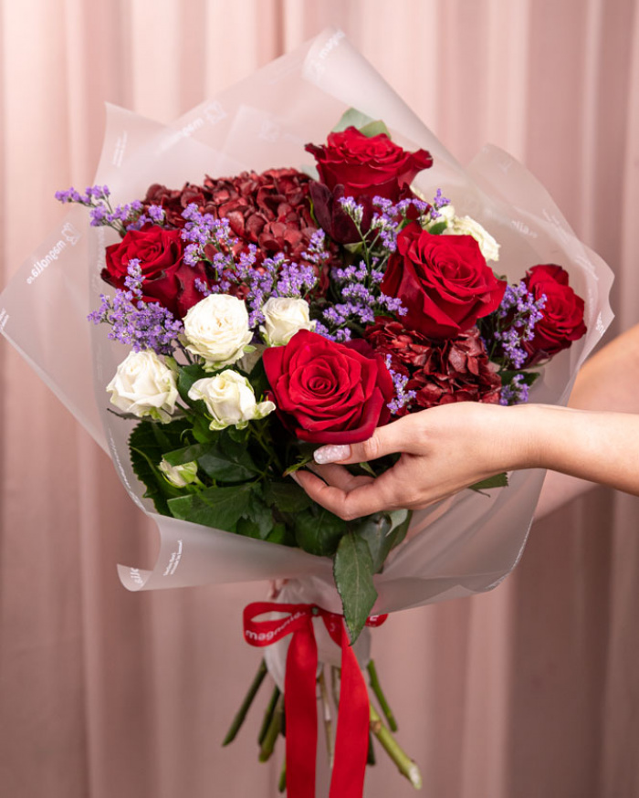 Perspectiva care evidentiaza proportiile si dimensiunea buchetului “Buchet cu Trandafiri și Hortensii”, varianta Premium, o compozitie bogata alcatuita din 5 Trandafiri Freedom, 2 Hortensii bordo, 2 Trandafiri ramificați albi, 1 fir de Limonium, 2 crenguțe de Eucalipt, finisata elegant cu ambalaj decorativ și panglică Magnolia.