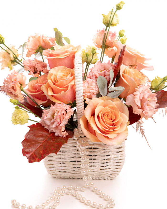 Imagine de ansamblu a coșului “Coș cu trandafiri portocalii și eustoma”, varianta Premium, realizat din 6 Trandafiri portocalii, 2 Eustoma somon, 1 ramură de Quercus, 1 fir de Asparagus cupru, 2 crenguțe de Eucalipt, completat cu 1 coș alb împletit și 1 șirag de mărgele.