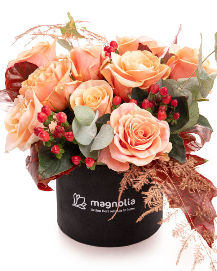 Imagine de ansamblu a cutiei “Cutie de toamnă cu trandafiri și hypericum”, varianta Premium, realizat din 9 Trandafiri portocalii, 2 ramuri de Hypericum, 1 crenguță de Quercus, 2 fire de Asparagus coloured și 1 crenguță de Eucalipt, completat cu o cutie rotundă neagră.