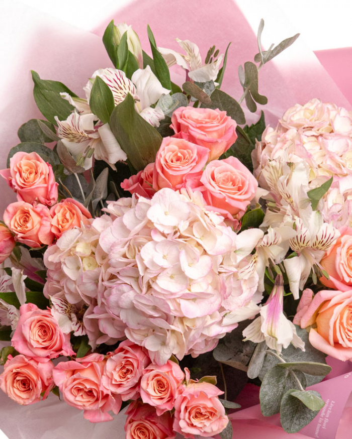 Prim-plan al florilor din buchetul “Buchet cu hortensii „Pink Dream””, varianta Premium, evidențiind combinația armonioasă de 5 Trandafiri ramificați roz, 2 Hydrangee roz, 3 Alstroemeria, completate de 2 crenguțe de Eucalipt și finisate cu ambalaj decorativ și 2 panglici Magnolia elegante.